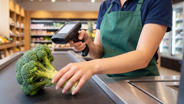 Grocery store cashier scanning a barcode at checkout